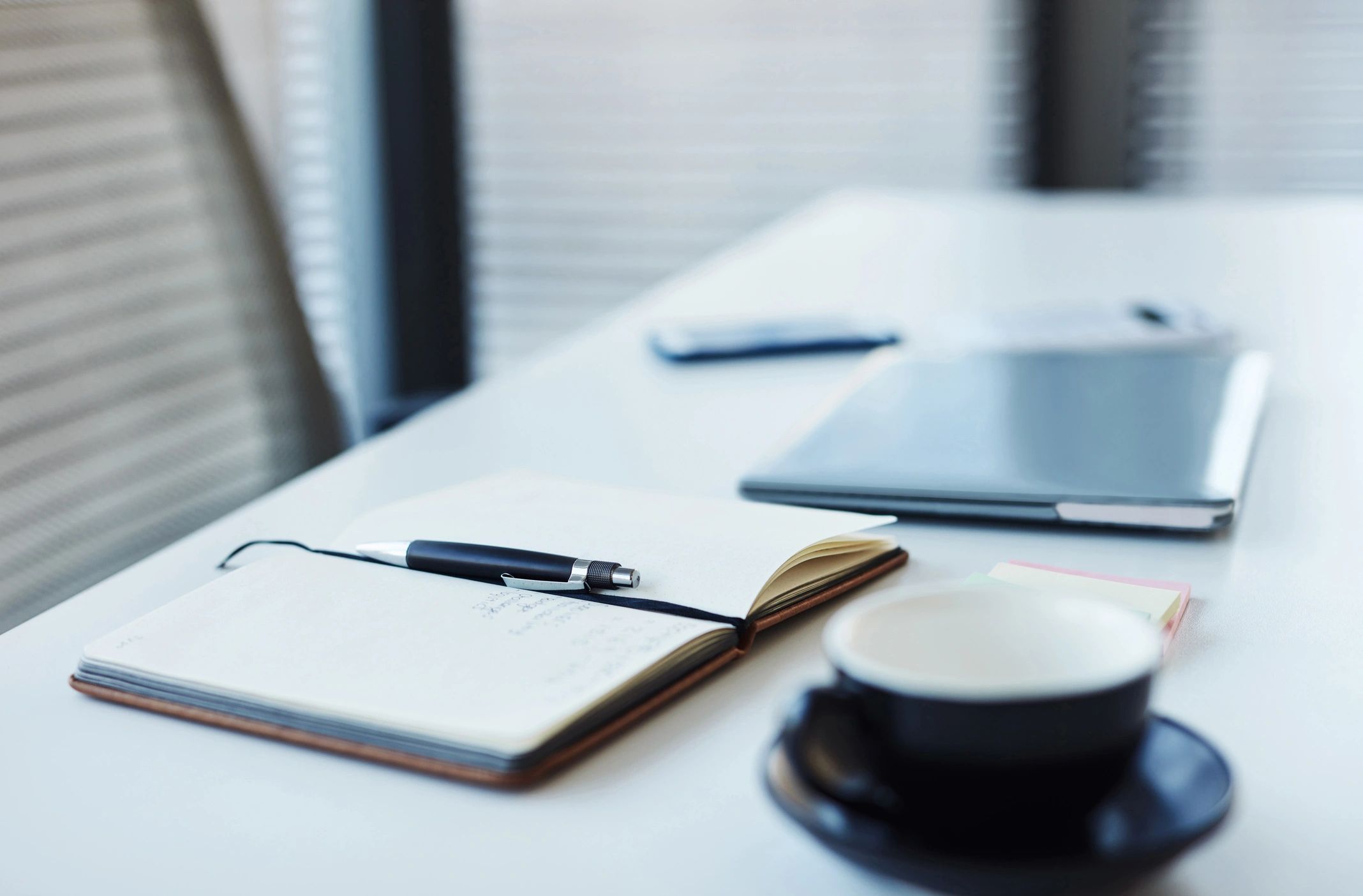 Closeup shot of a notebook and laptop on a tablet in an office